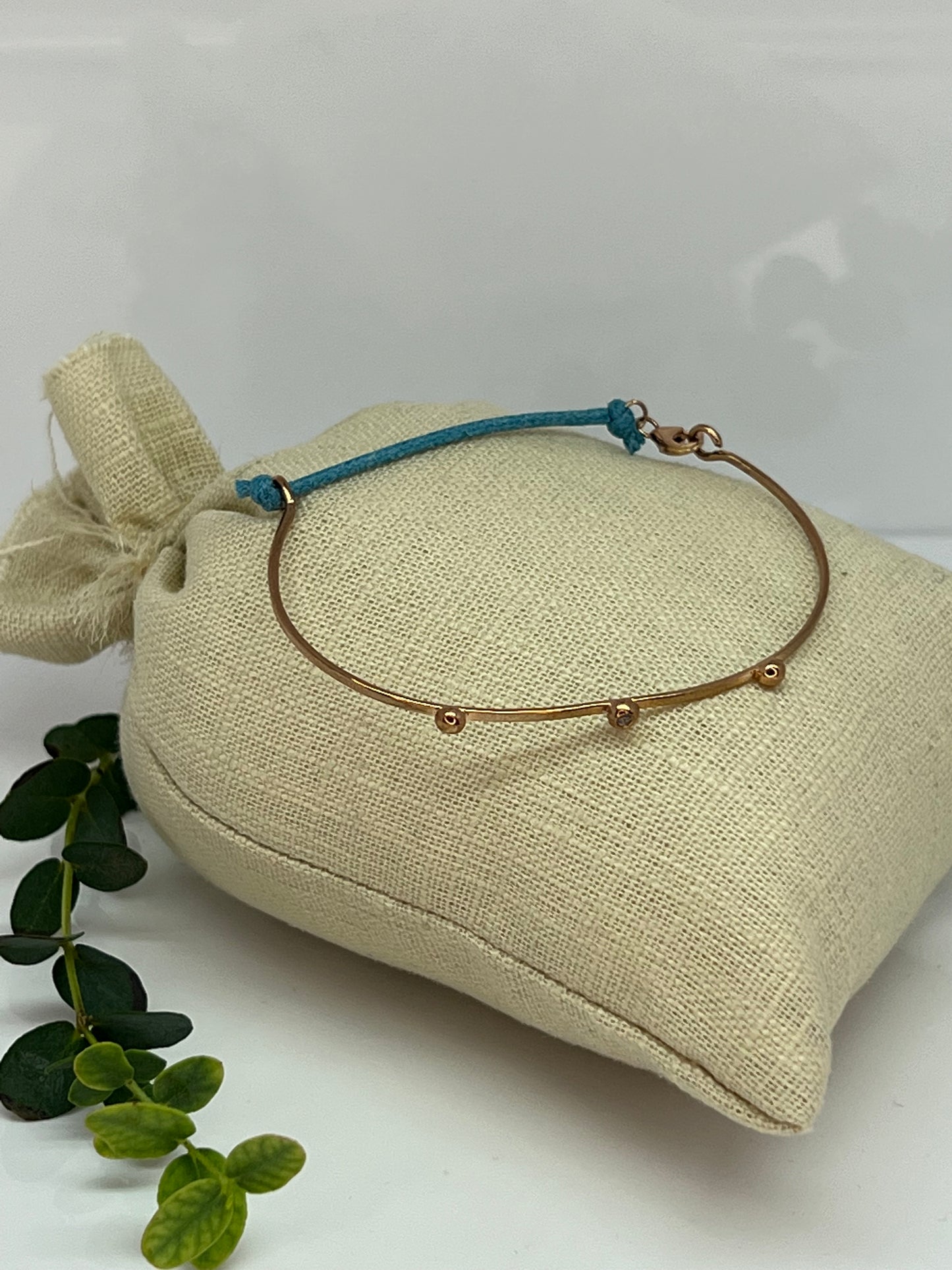 BRACCIALE IN ORO RIGIDO CON LACCETTO DI STOFFA E ZIRCONCINO AZZURRO
